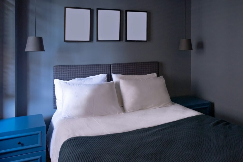 Modern bedroom in luxury apartment in dark blue colors with picture foto frames